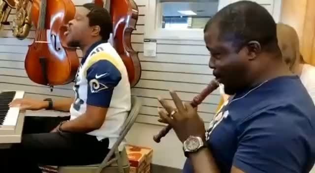Soji playing flute beside a pianist