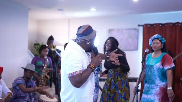Soji leading praise among a gathering of worshippers