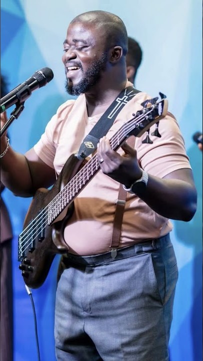 Soji playing bass on a blue-lit stage